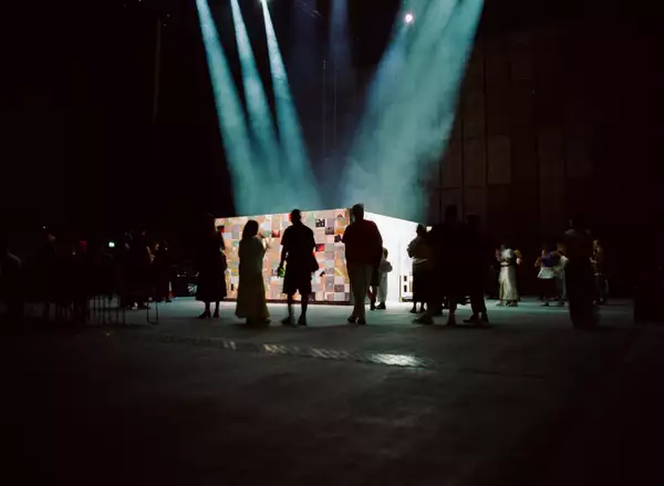 A group of people watching 54: Manchester's installation in the Warehouse.