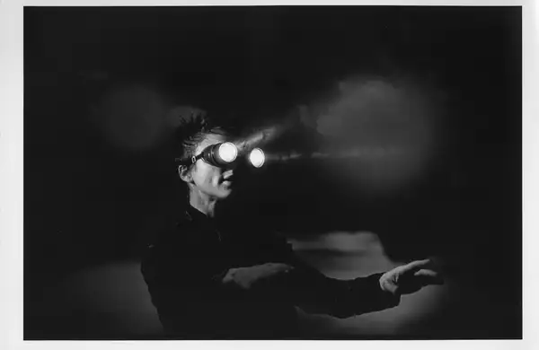 Black and white still from Laurie Anderson's United States Parts 1–4, showing Laurie wearing goggles with lights on