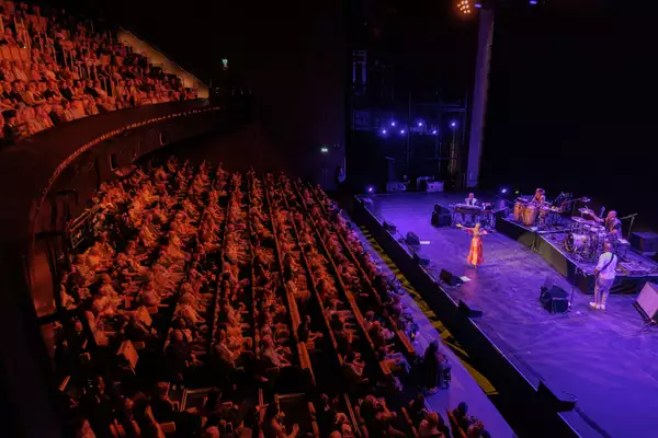 Photo of Angelique Kidjo performing on stage and audience watching