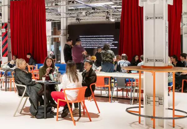 Visitors in Aviva Studios sitting down in the social area.