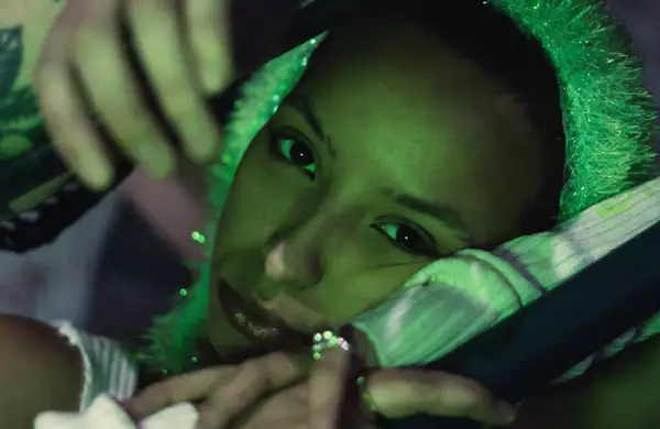 A green light shines on singer Karis Jade