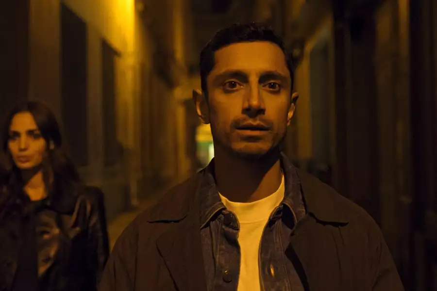 A still from DAMMI showing Riz Ahmed and co-star on a dimly-lit street
