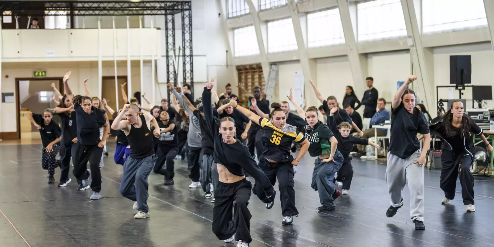 Dancers for Free Your Mind with one arm raised in rehearsals