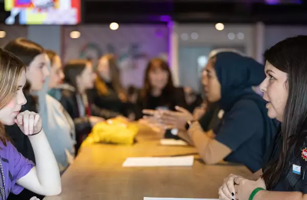 Mentors and mentees talking on a long table