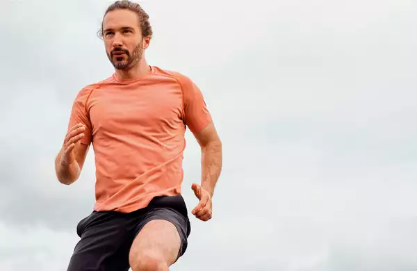 Joe Wicks running in an orange t-shirt
