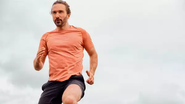 Joe Wicks running in an orange t-shirt