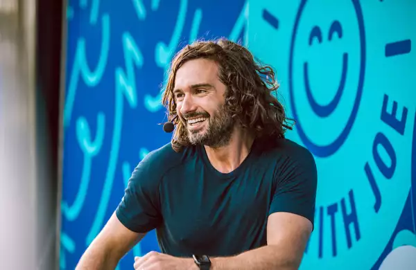 Joe Wicks smiling with a microphone