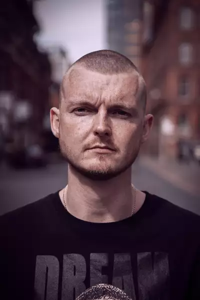 Dancer Mark Boyce wearing a black t-shirt and neck chain
