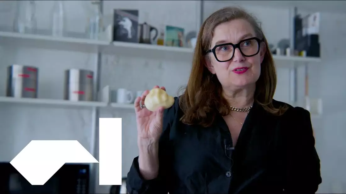 Ju from Blast Theory holding up a clay artwork in the shape of a human heart