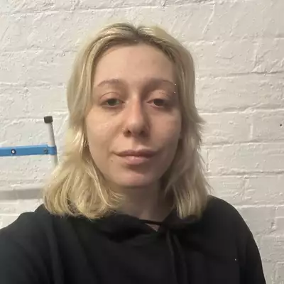 Square headshot of Madison Marcantonatos against a cream wall, wearing a black hooded jumper