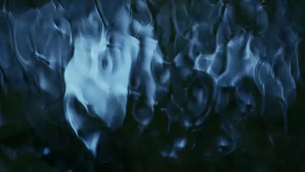 This image has an abstract, fluid-like pattern with deep blue and black tones, creating a sense of flowing water or rippling textures.