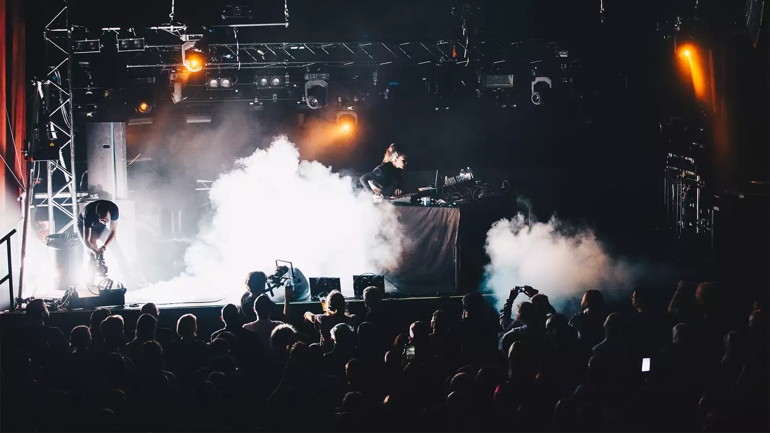 Artist Aisha Devi on stage with dj decks with plums of smoke