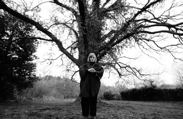 black and white photo of Maxine Peake stood in front of a large tree